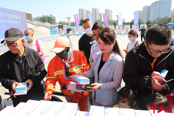 内蒙古总工会副主席吴燕平（左三）向群众发放网络安全知识宣传手册、书签。 刘旭亮 摄